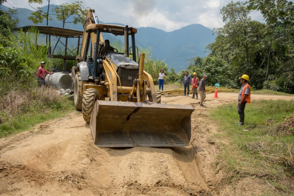 Photo of construction workers around a loader on dirt road