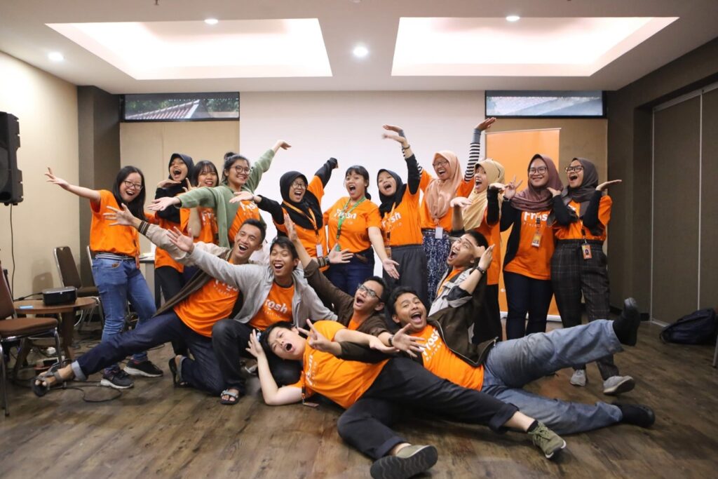 Young men and women in orange shirts pose for the camera as part of PeaceGen gathering at the Indonesian University of Education.